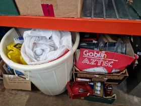 A large plastic basket of golf balls and bundle of golf balls and accessories.
