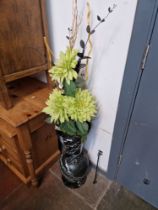 A black marble vase containing silk flowers.