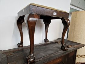A mahogany stool on ball and claw feet.