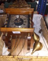 A vintage wall clock with brass weights and pendulum.