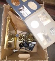 A box of assorted items including a war time photograph album, candlesticks, two photograph frames.