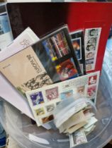 A tub of assorted first day covers, PHQs and loose mint stamps