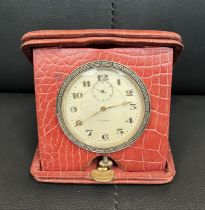 A red leather cased 8 day travelling clock