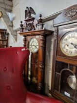 A walnut cased Vienna wall clock with pendulum and key.