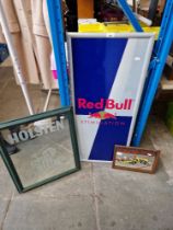 A Red Bull advertising sign together with a Holsten advertising mirror and a Snoopy mirror.