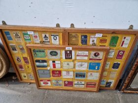 Three framed displays of vintage cigarette box covers.