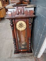 A mahogany cased Vienna wall clock with pendulum and key.