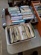 A box of DVDs and a box of 7" vinyl 45s.