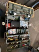 A fishing tackle box containing various lures, flies, spinners and spoons, triple hooks, weights,
