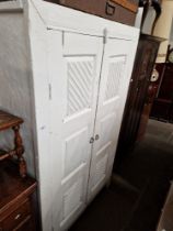 A rustic white painted linen press.