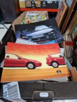 A box of various car sales brochures.
