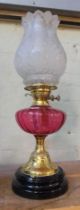 An Art Nouveau pink glass and brass oil lamp with frosted glass shade, height 57cm.