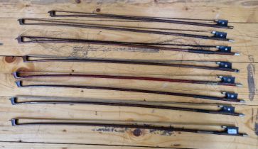 A group of eight violin bows.