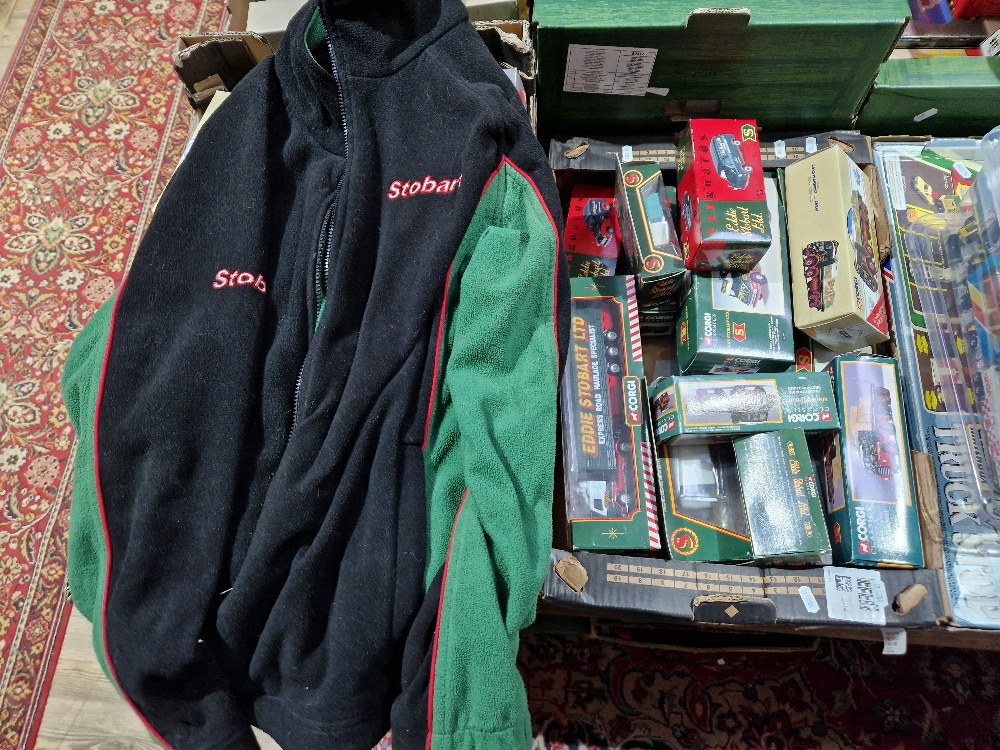 A box of assorted boxed Eddie Stobart Corgi diecast vehicles & an Eddie Stobart fleece jacket.