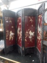 A Chinese black lacquer folding screen decorated with birds.