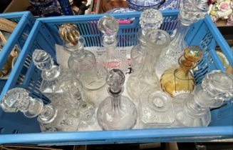 A crate containing 11 decanters (9 with stoppers) and other items of glassware