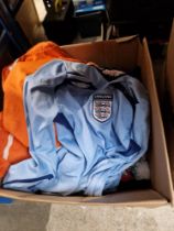 A box of mixed football shirts, shorts, scarves and a Man United fleece.