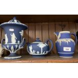 Three pieces of Wedgwood jasper ware in dark blue - lidded, twin handled urn, teapot, and tall jug
