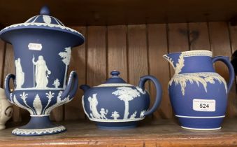 Three pieces of Wedgwood jasper ware in dark blue - lidded, twin handled urn, teapot, and tall jug