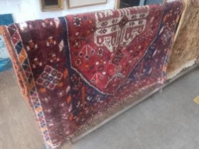 A vintage Middle Eastern hand knotted wool carpet, red ground, 165cm x 116cm (approx).