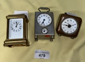 A miniature brass carriage clock and two other miniature clocks.