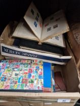 A box with various stamp albums, tea cards, various other items, etc.