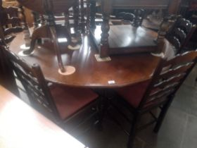 An aged oak dining table and six chairs.