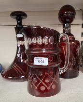 Two cranberry glass decanters, with stoppers, and a similar water jug