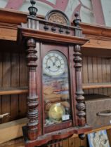 A Vienna clock with brass and enamel face, pendulum and key.