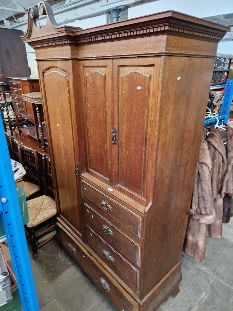 An Edwardian oak wardrobe, the locks stamped 'GILLOWS LANCASTER'.