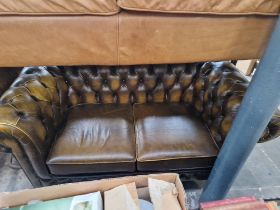 A brown leather Chesterfield sofa.