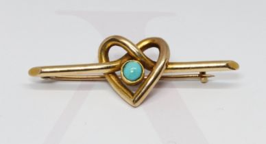 An Edwardian bar brooch formed from an entwined heart design with central turquoise cabochon, marked