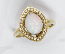 An opal and diamond cluster ring, the central opal cabochon measuring approximately 9.86mm x 7.85mm,