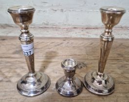 A pair of silver candlesticks, Birmingham, AT Cannon Ltd, 1969 together with another candlestick.