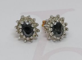 A pair of sapphire and colourless stone cluster ear studs, one pin hallmarked 9ct gold, gross weight