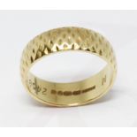 An 18ct gold wedding band, D section band with exterior pattern, sponsor 'BW&SL', London 1970,