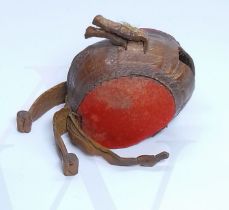 A 19th century leather and red fabric falconry hood, length 6.5cm.
