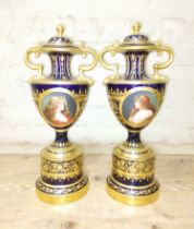 A large pair of 'Vienna' porcelain urns, gilt decoration on blue ground with painted panels entitled