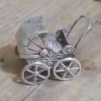 A novelty white metal miniature pram, marked '925', length 38mm.