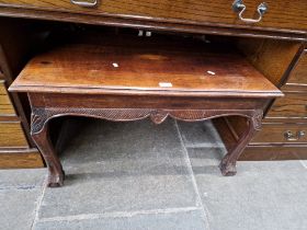 A mahogany coffee table on ball and claw feet.