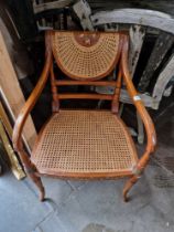 A Regency style cane seat armchair with painted decoration.