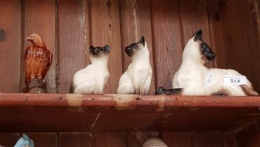 Three Beswick Siamese cats and a miniature Beneagles whisky eagle