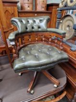 A green leather Chesterfield captain's chair.