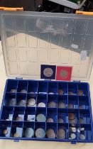 A case containing vintage coins and two commemorative crowns