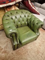 A green leather Chesterfield club chair.