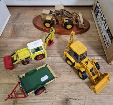 Four model JCB diggers/trailer comprising one presentation model on plinth, one by NZG, another by
