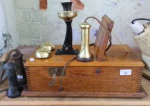 An early 20th century oak cased telephone with brass fittings, stamped 'C.100.L'.