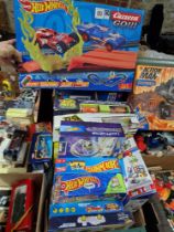 A box of assorted Hot Wheels sets and a Rip Spin Warriors set.
