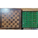 A tooled leather chess board, with cast metal chess pieces in fitted drawer.