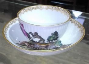 A Meissen cup and saucer, circa 1800, hand painted decoration depicting a monkey, a horse, a dog and